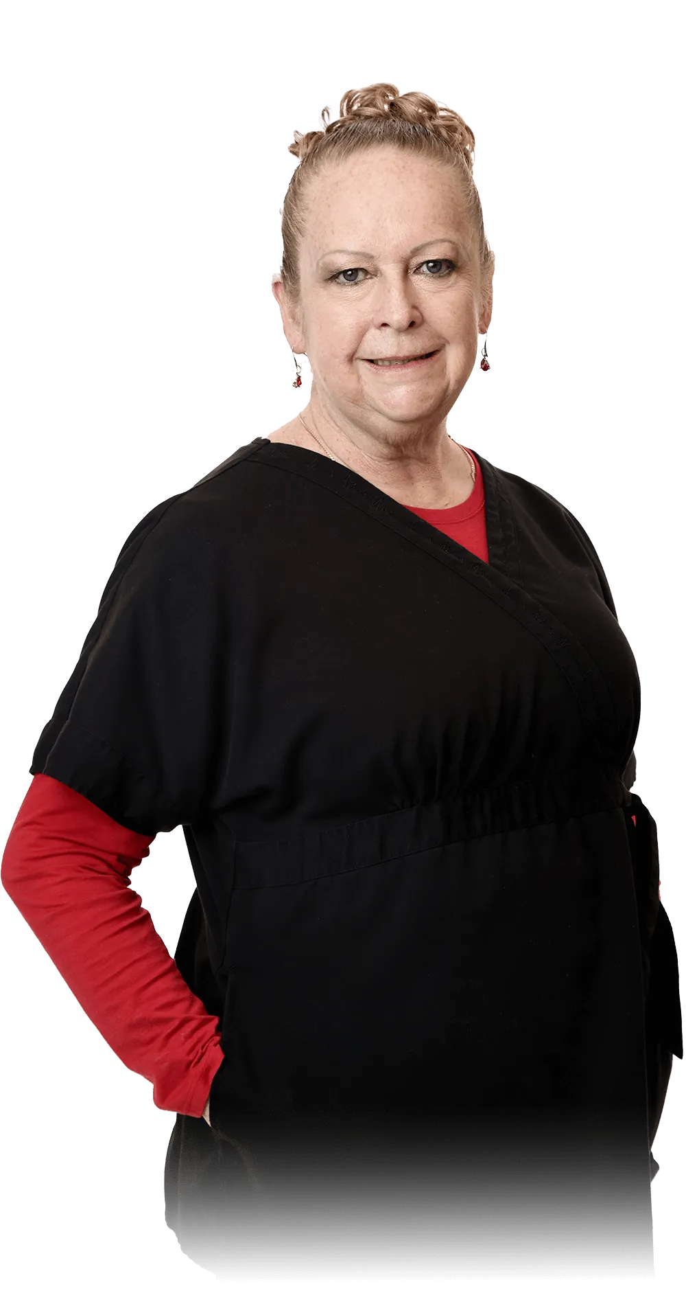 Portrait of Katherine T. with blonde hair styled up and wearing a black tunic with a red undershirt, adorned with earrings. She stands confidently with her arms at her sides, sporting a warm smile, and a name badge indicating she is part of the Vartanian Dental Group.